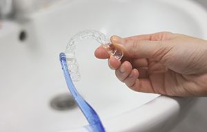 Patient cleaning aligner with toothbrush
