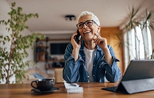 Woman smiling while talking on phone at home