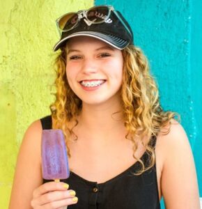 Teen girl with braces eating a popsicle 